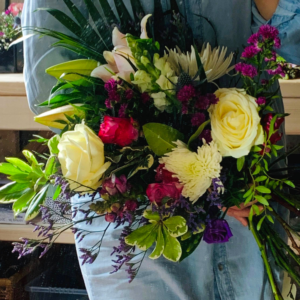 Bridal bouquet over arm extra large roses lillies sea lavendar lisianthus sea holly foliage by HM Floristry